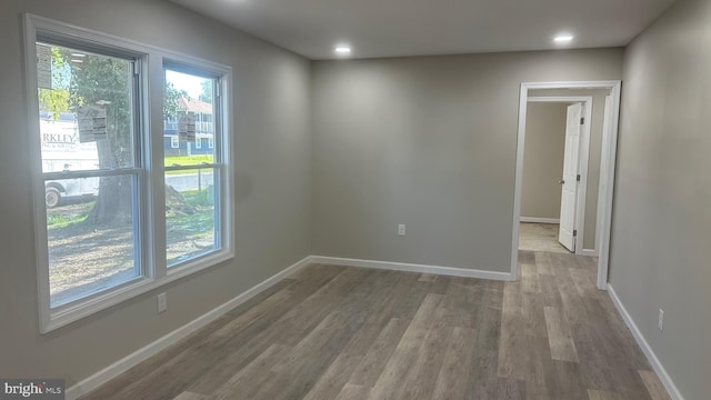 empty room featuring recessed lighting, wood finished floors, and baseboards