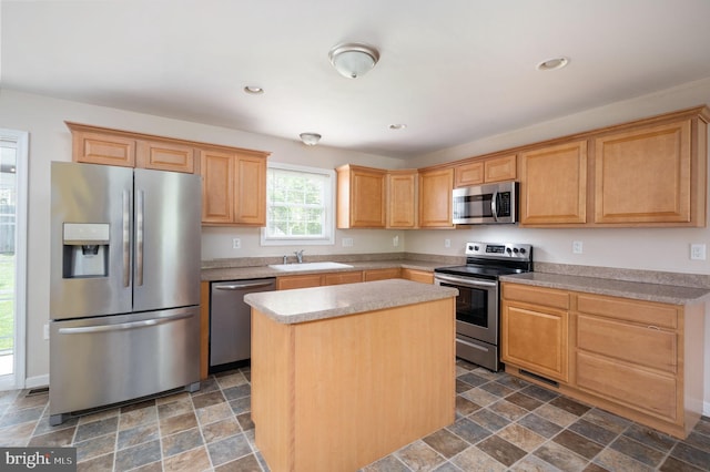 kitchen featuring a center island, a sink, appliances with stainless steel finishes, stone finish floor, and recessed lighting