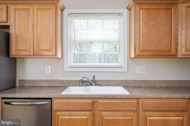 kitchen featuring a sink, light countertops, stainless steel dishwasher, and light brown cabinets