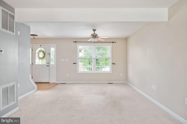 entryway with baseboards, visible vents, and carpet floors