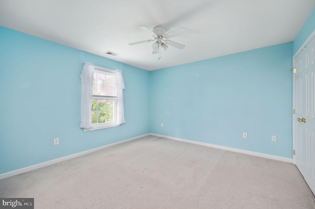 unfurnished room with visible vents, ceiling fan, baseboards, and light carpet