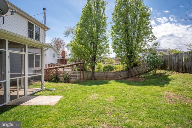 view of yard featuring a fenced backyard and a sunroom