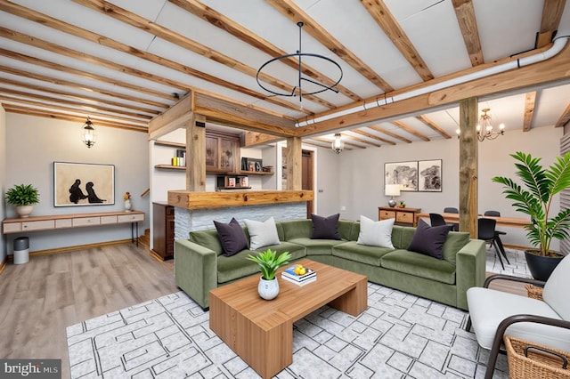 living room featuring an inviting chandelier, beamed ceiling, and baseboards