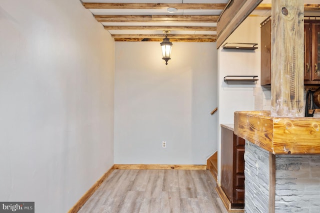 unfurnished dining area with baseboards and wood finished floors