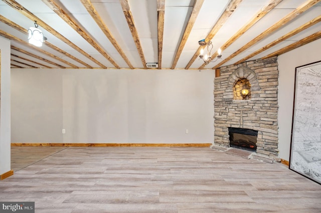 basement featuring a stone fireplace, wood finished floors, and baseboards