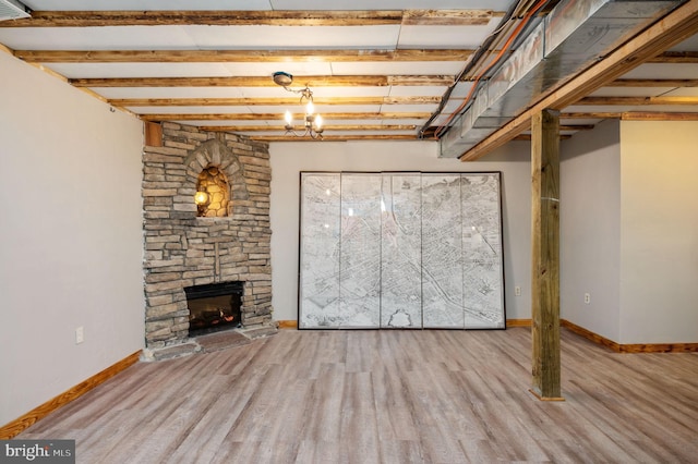 finished basement with baseboards, wood finished floors, and a fireplace