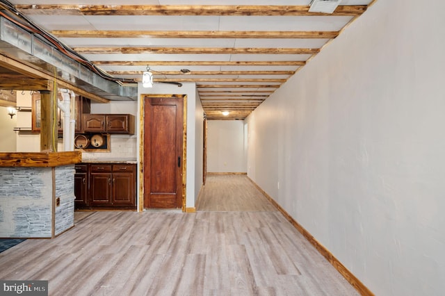 basement featuring light wood-type flooring and visible vents
