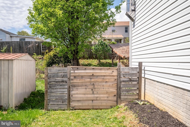 view of yard featuring fence, an outbuilding, and a storage unit
