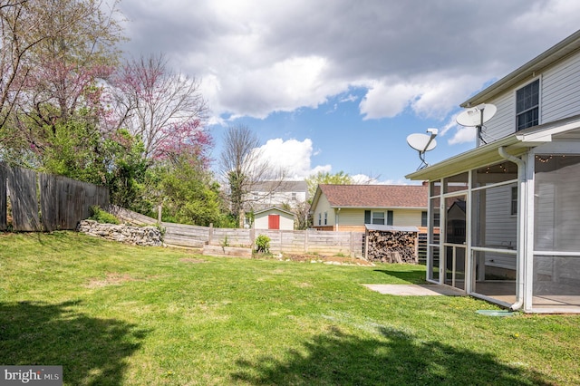 view of yard featuring a fenced backyard and a sunroom