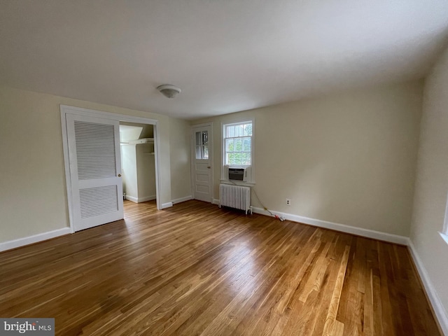 interior space featuring baseboards, radiator, and wood finished floors