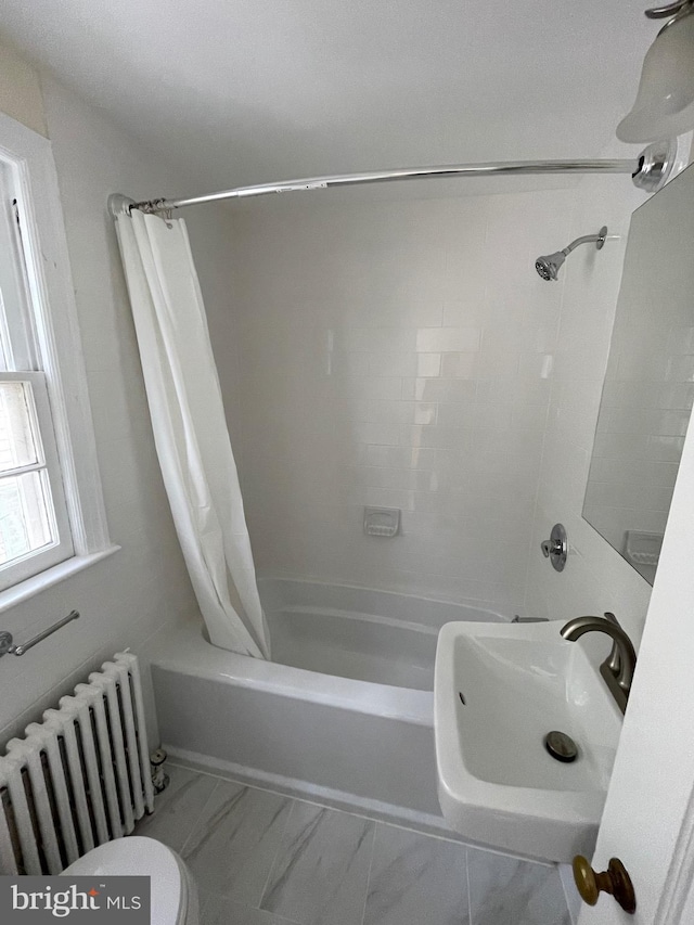 bathroom featuring shower / tub combo, toilet, radiator heating unit, marble finish floor, and a sink