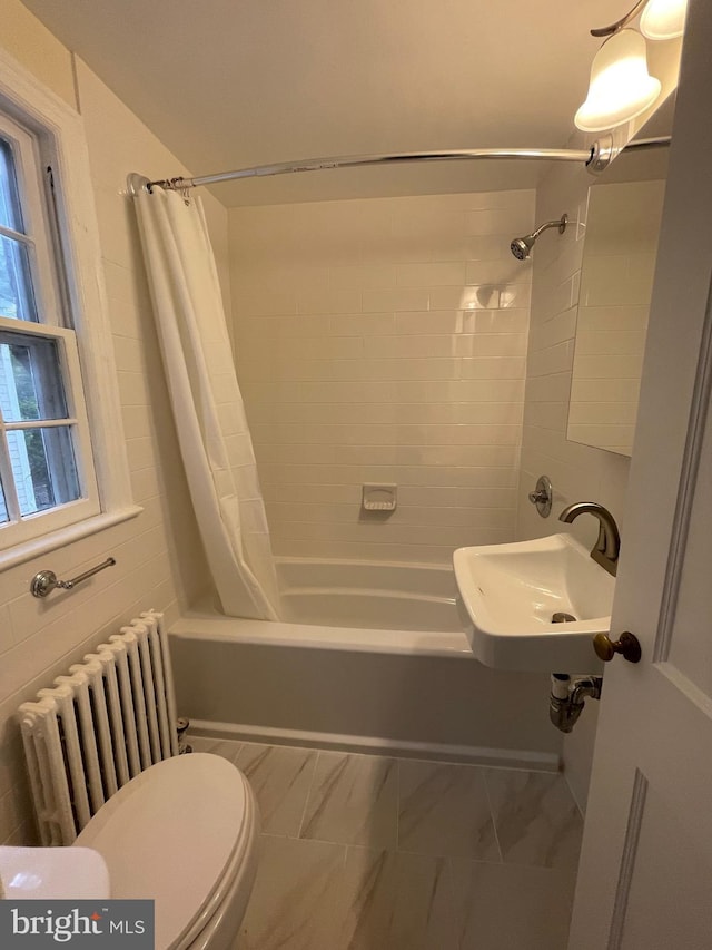bathroom featuring a sink, toilet, shower / tub combo with curtain, radiator, and marble finish floor