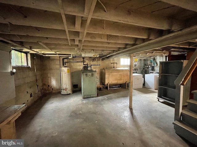 basement featuring heating fuel, stairway, heating unit, gas water heater, and washer and clothes dryer