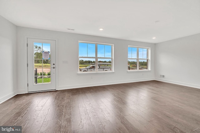 interior space with dark wood-type flooring, baseboards, visible vents, and recessed lighting