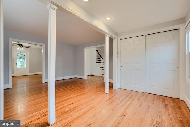 unfurnished bedroom featuring decorative columns, light wood-type flooring, baseboards, a closet, and recessed lighting