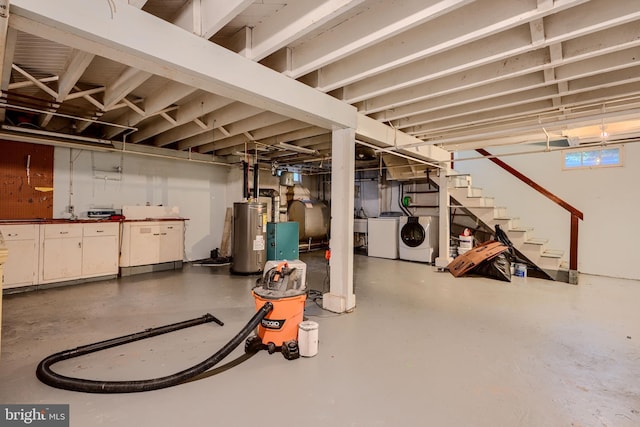basement featuring a sink, heating fuel, washing machine and dryer, stairway, and electric water heater
