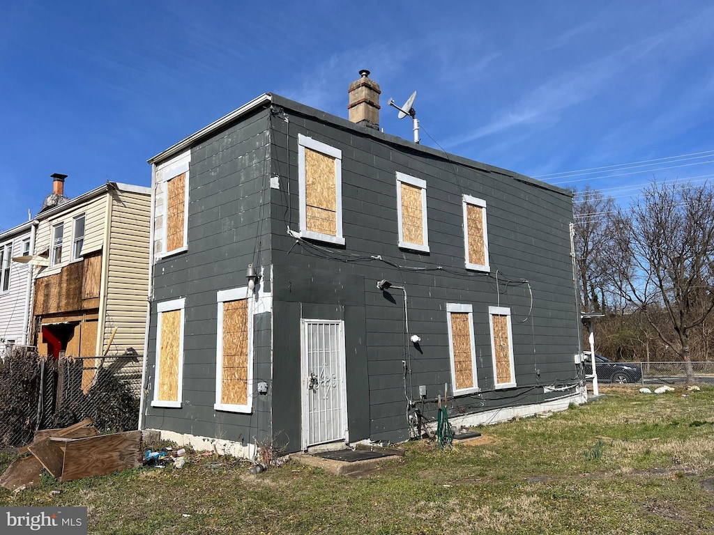 2109 Fairlawn Ave SE, Washington, DC 20020 - back of house featuring a lawn, fence, and a chimney