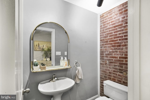 1240 Leopard St, Philadelphia, PA 19125 - half bathroom featuring brick wall, a sink, and toilet