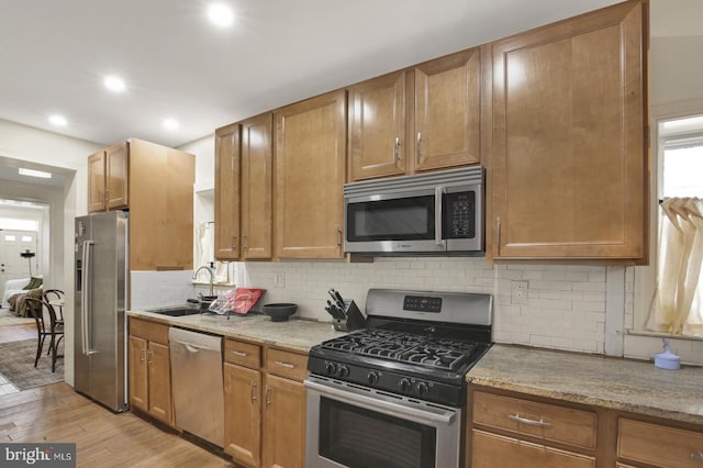 1240 Leopard St, Philadelphia, PA 19125 - kitchen with a sink, light wood-type flooring, light stone countertops, backsplash, and stainless steel appliances