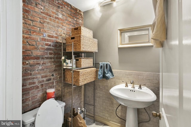 1240 Leopard St, Philadelphia, PA 19125 - half bathroom with brick wall, tile patterned flooring, a wainscoted wall, toilet, and tile walls