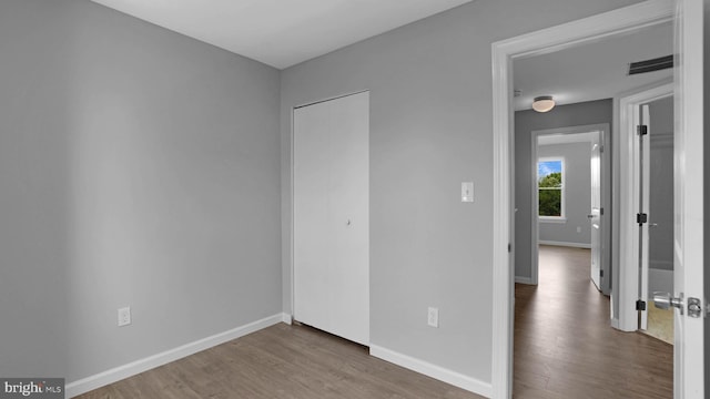 1315 Riverwood, Baltimore, MD 21226 - unfurnished bedroom with visible vents, baseboards, wood finished floors, and a closet