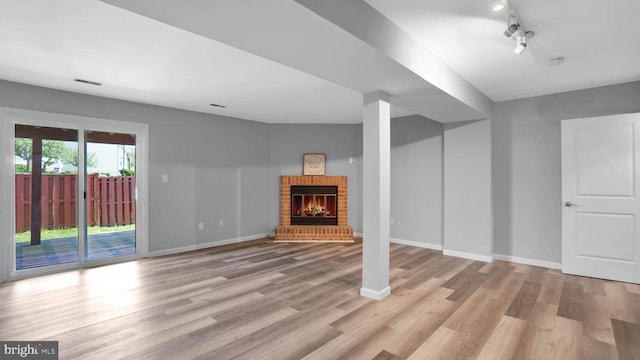 1315 Riverwood, Baltimore, MD 21226 - below grade area with light wood-type flooring, baseboards, a brick fireplace, and visible vents