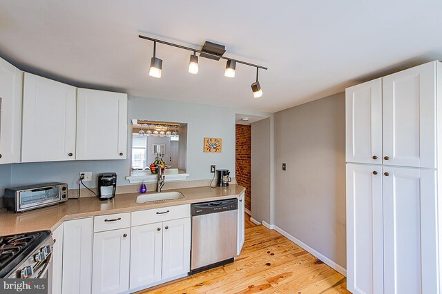 kitchen with light wood-style flooring, a toaster, appliances with stainless steel finishes, white cabinetry, and a sink