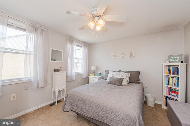 bedroom featuring a ceiling fan, light carpet, and baseboards