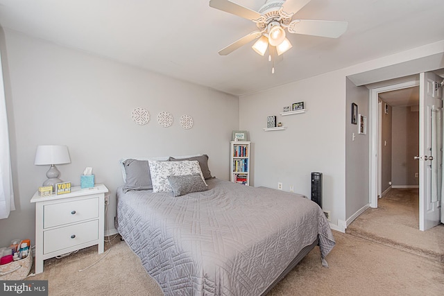 bedroom featuring baseboards, light colored carpet, and ceiling fan