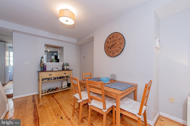 dining area with baseboards and light wood-style floors