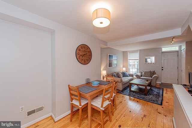 dining area with baseboards, visible vents, and light wood-style floors