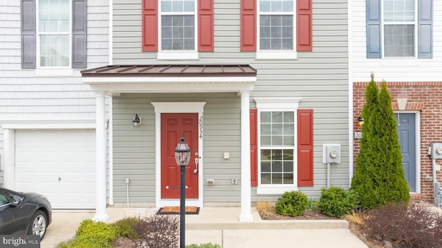 entrance to property featuring a standing seam roof, metal roof, and an attached garage