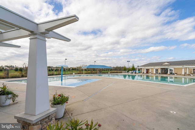 community pool with a patio and fence