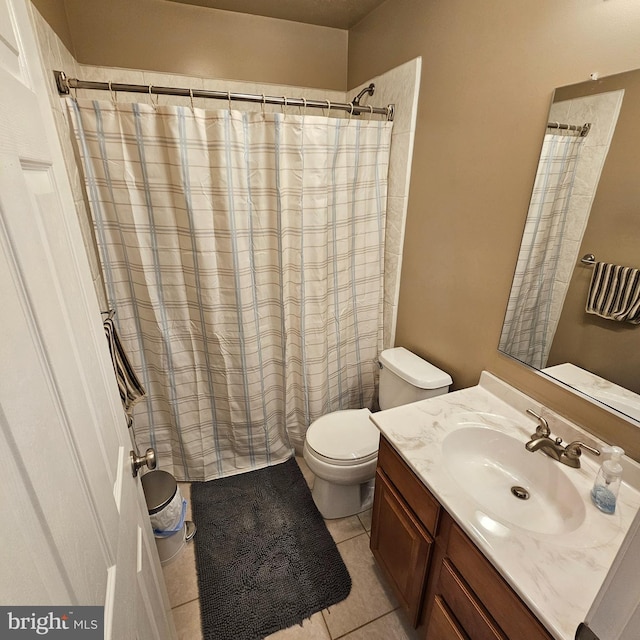 bathroom with toilet, tile patterned floors, curtained shower, and vanity