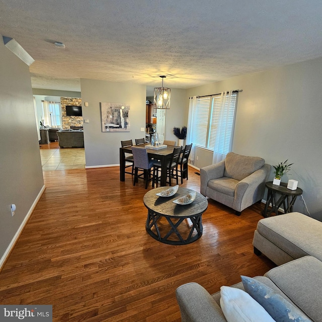 living area with a textured ceiling, baseboards, and plenty of natural light