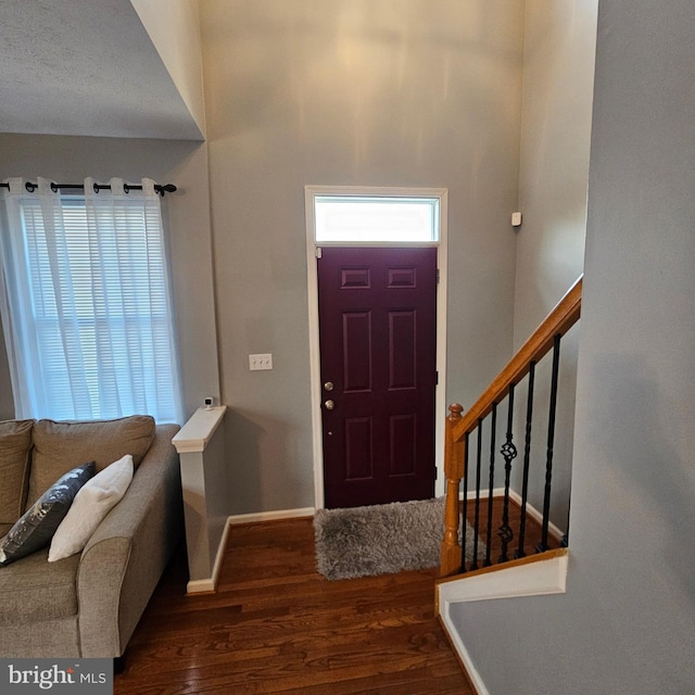 entrance foyer with wood finished floors, baseboards, and stairs