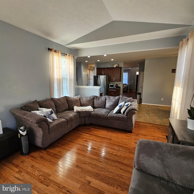 living room with wood finished floors and vaulted ceiling
