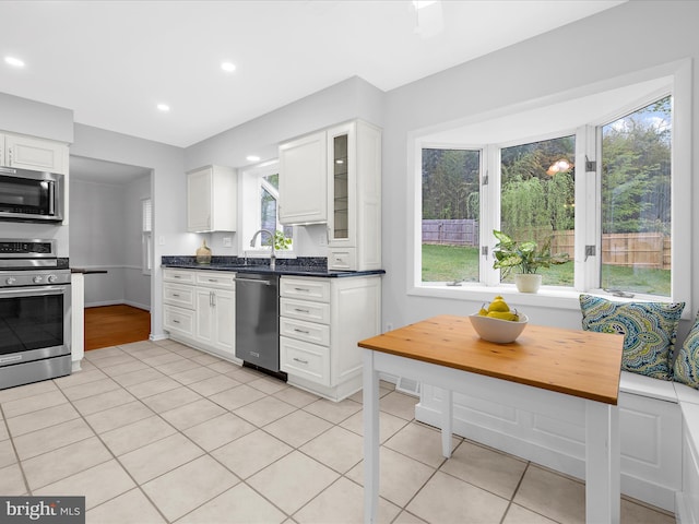 142 Tall Tree Trl, Arnold, MD 21012 - kitchen featuring light tile patterned floors, glass insert cabinets, white cabinetry, and appliances with stainless steel finishes