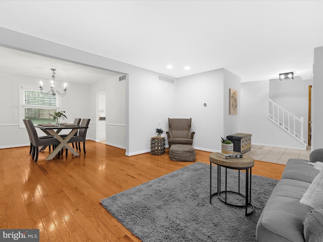 142 Tall Tree Trl, Arnold, MD 21012 - living area with a chandelier, light wood-style flooring, visible vents, and stairs