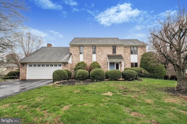 28 Beech Hill Dr, Newark, DE 19711 - view of front of house featuring a front lawn, driveway, a chimney, brick siding, and an attached garage