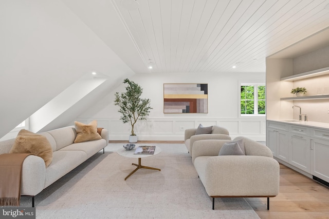 living room with recessed lighting, light wood-style flooring, bar with sink, a wainscoted wall, and wooden ceiling