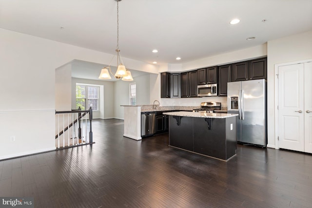 5542 Peanuts Ln, Waldorf, MD 20602 - kitchen with light stone countertops, appliances with stainless steel finishes, a kitchen breakfast bar, dark wood finished floors, and recessed lighting
