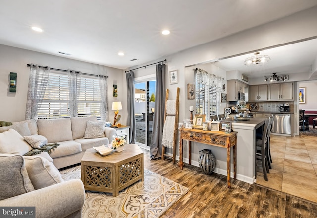 living room with light wood finished floors, an inviting chandelier, visible vents, and recessed lighting