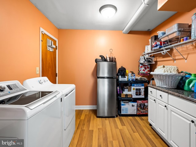 laundry area with light wood-type flooring, laundry area, baseboards, and washer and clothes dryer