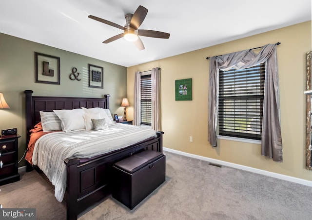 carpeted bedroom featuring visible vents, baseboards, and a ceiling fan