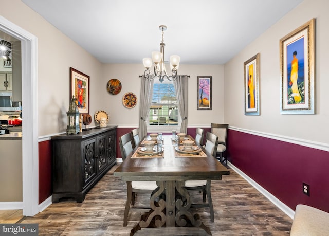 dining room featuring baseboards, a chandelier, and wood finished floors