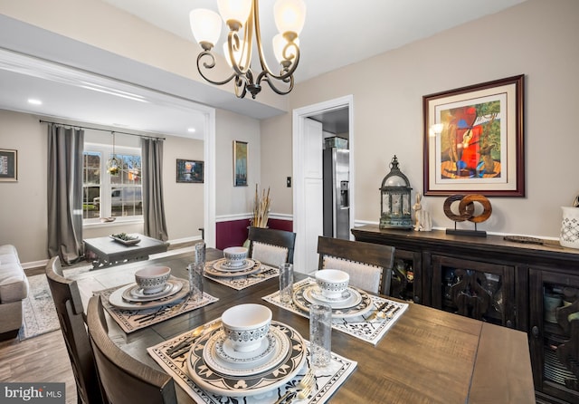 dining room featuring baseboards, an inviting chandelier, and wood finished floors