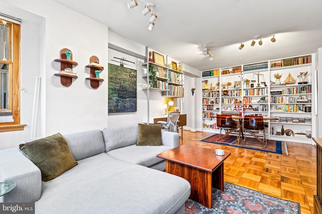 living room featuring rail lighting and built in shelves
