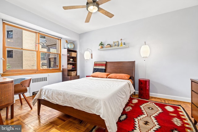bedroom featuring radiator, baseboards, and a ceiling fan
