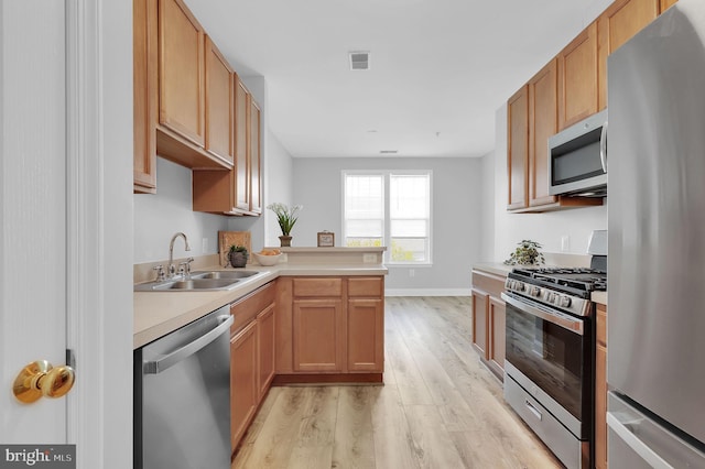 503 King Farm Blvd Unit 306, Rockville, MD 20850 - kitchen featuring stainless steel appliances, a sink, light wood-style flooring, light countertops, and a peninsula